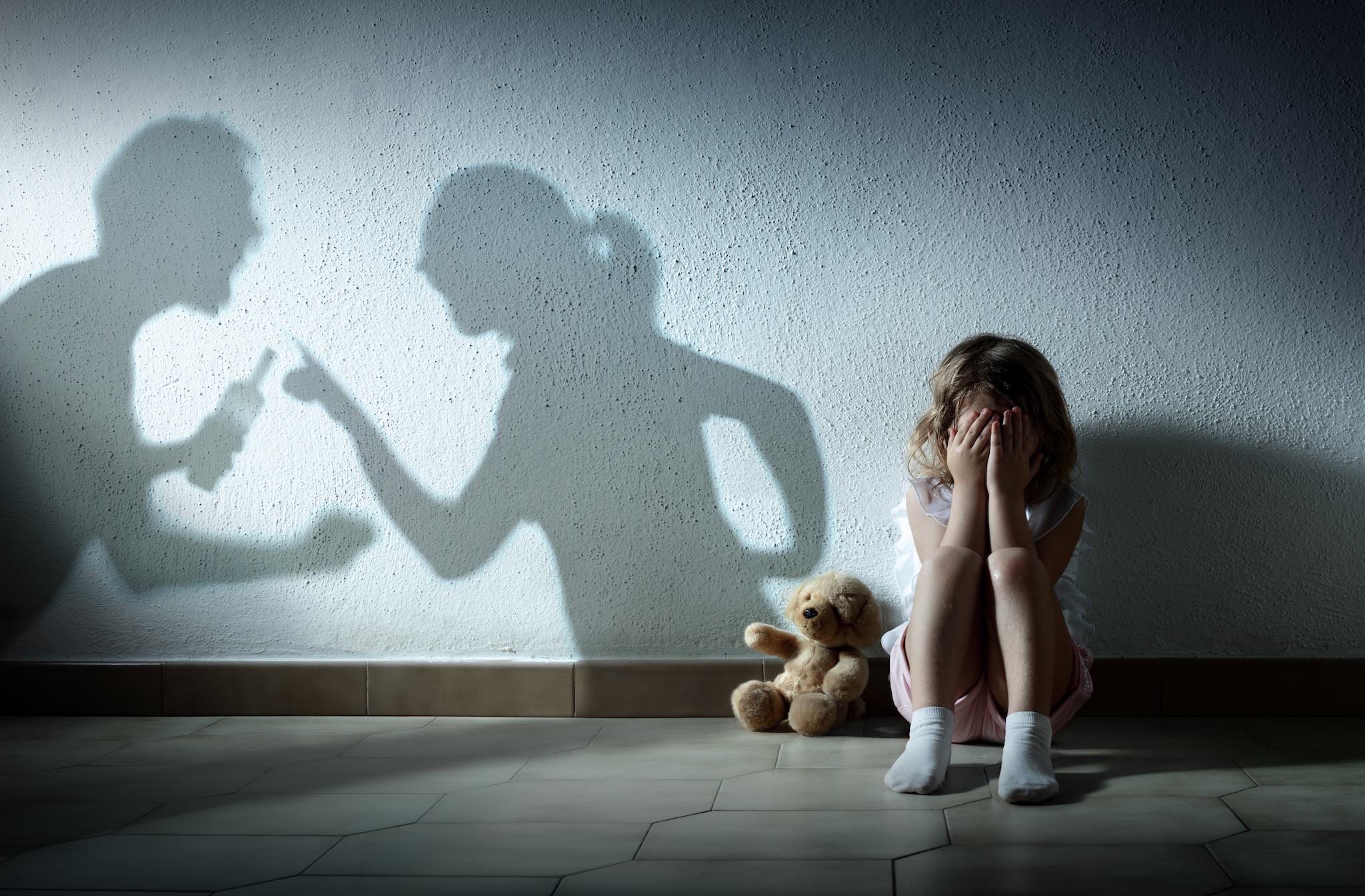 a girl sitting on the floor with her hands on her face